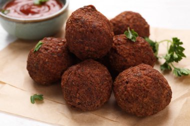 Falafel köfteleri ve parşömen kağıdında maydanoz, yakın plan. Vegan et ürünleri