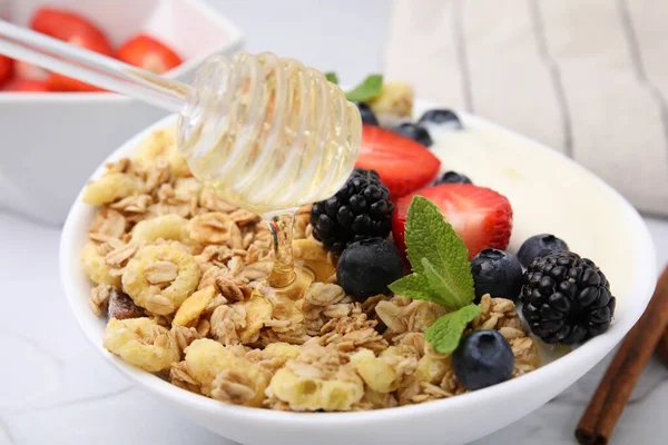 将蜂蜜倒在美味的燕麦和新鲜的浆果在碗里 健康早餐 — 图库照片