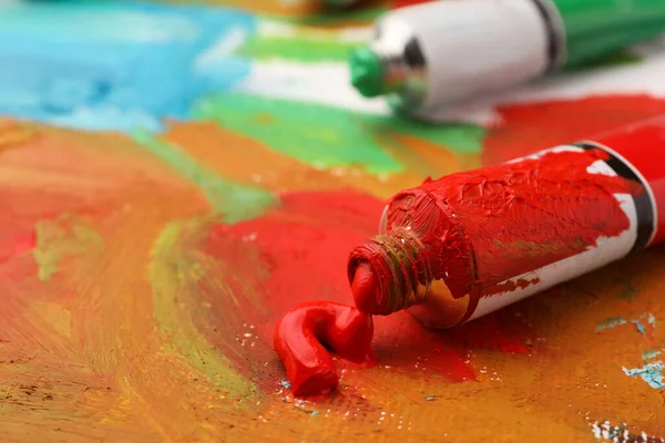 Tubo Tinta Óleo Vermelha Sobre Tela Com Pintura Abstrata Close — Fotografia de Stock