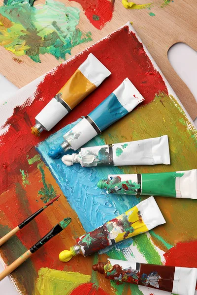 Renkli Boya Tüpleri Fırçalar Beyaz Masa Üzerinde Soyut Boya Ile — Stok fotoğraf