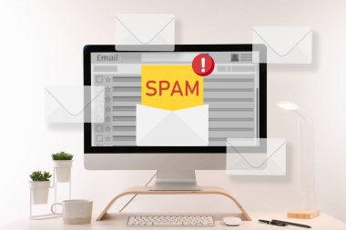E- posta yazılımında çöp posta uyarısı. Ofis masasındaki bilgisayar ekranından çıkan zarf çizimleri