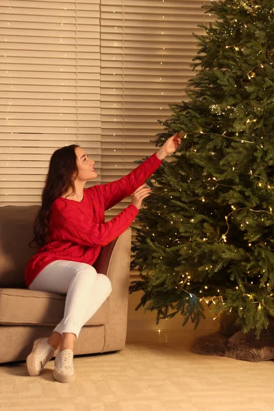 Güzel Bir Kadın Noel Ağacının Yanında Oturma Odasında Altın Işıklar — Stok fotoğraf