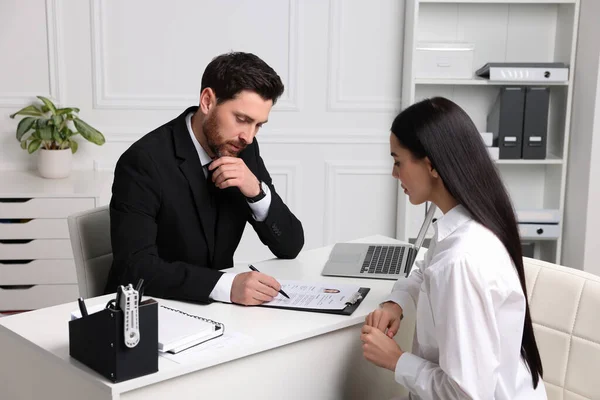 stock image Human resources manager reading applicant's resume during job interview in office