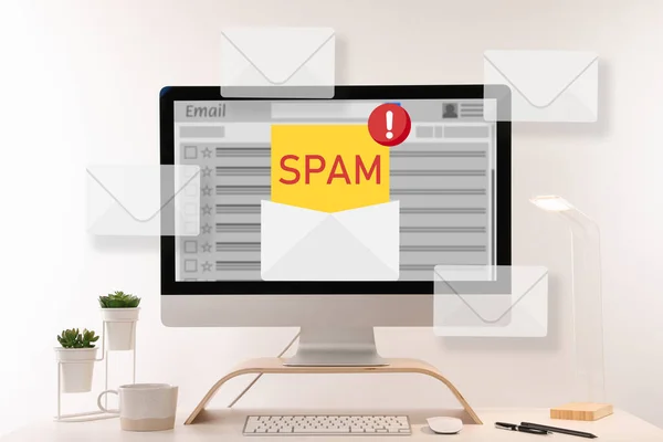 电子邮件软件中的垃圾邮件警告信息 从办公室桌上的计算机显示屏上弹出的信封插图 — 图库照片