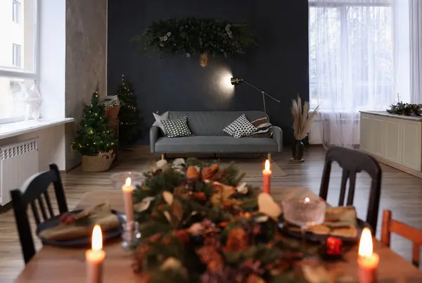 スタイリッシュな部屋で燃えるキャンドルやクリスマスの装飾とダイニングテーブル インテリアデザイン — ストック写真