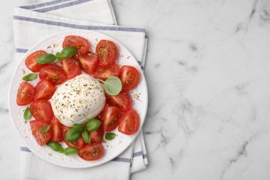 Peynirli Caprese salatası, domates ve fesleğen, beyaz mermer masa, üst manzara. Metin için boşluk