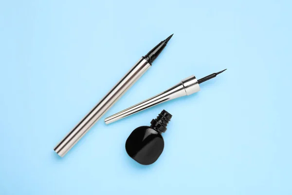 Black Eyeliners Light Blue Background Top View Makeup Product — Stock Photo, Image