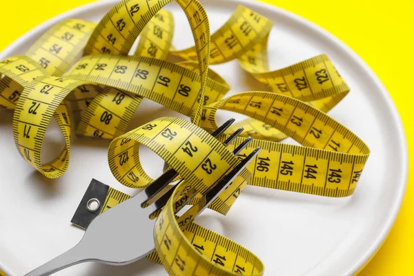 Maßband Und Gabel Auf Gelbem Hintergrund Nahaufnahme Konzept Zur Gewichtsreduktion — Stockfoto