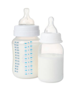 Beyaz arka planda bebek mamasıyla beslenen iki şişe.