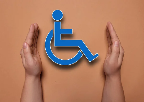 Włączenie Niepełnosprawności Kobieta Chroniąca Symbol Wózka Inwalidzkiego Koralowym Tle Zbliżenie — Zdjęcie stockowe