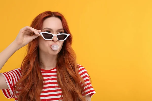 Mooie Vrouw Met Een Zonnebril Die Kauwgom Blaast Oranje Achtergrond — Stockfoto