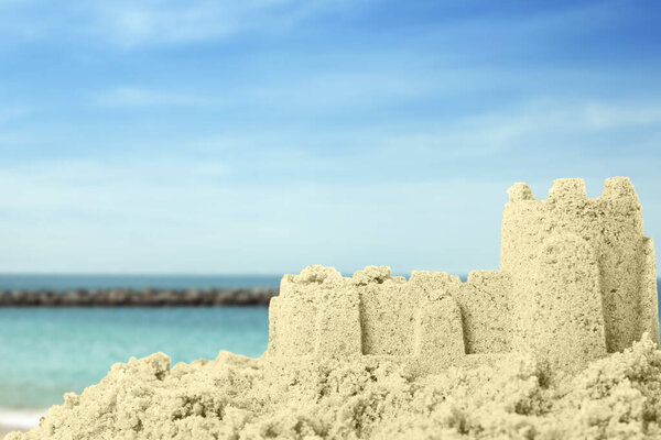 Sand castle on ocean beach, closeup with space for text. Outdoor play