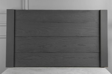 Açık gri duvarın yanındaki masada tahta tahta tahta var.