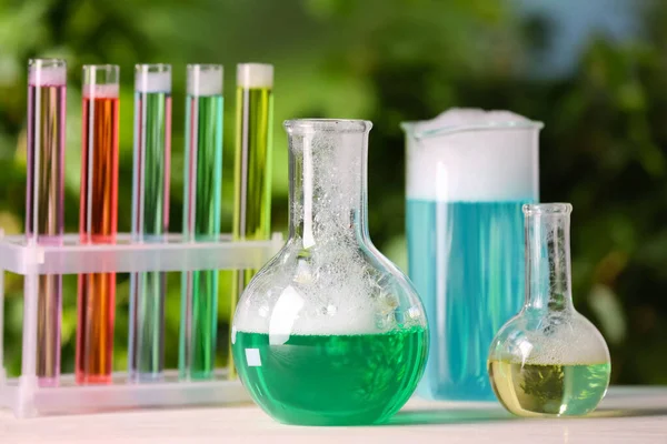 Wyroby Laboratoryjne Szklane Probówki Kolorowymi Płynami Białym Stole Świeżym Powietrzu — Zdjęcie stockowe