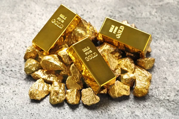 Goldbarren Und Nuggets Auf Hellgrauem Tisch — Stockfoto