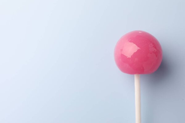 Tasty lollipop on light blue background, top view. Space for text