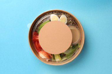 Açık mavi arka planda, konteynırda leziz yemekler, üst manzara. Metin için boşluk