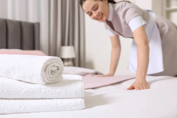 ホテルの部屋でベッドを作る若いメイド 選択的な焦点 — ストック写真