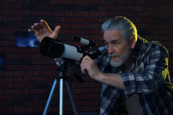 Старший Мужчина Смотрит Звезды Через Телескоп Комнате — стоковое фото