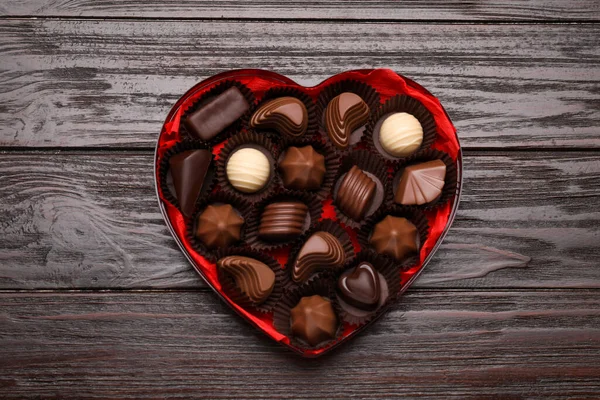 Hartvormige Doos Met Heerlijke Chocolade Snoepjes Houten Tafel Bovenaanzicht — Stockfoto