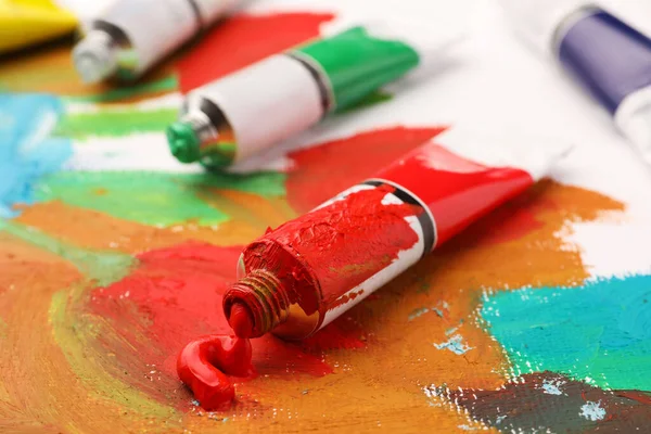 Tubos Tintas Óleo Coloridas Sobre Tela Com Pintura Abstrata Close — Fotografia de Stock