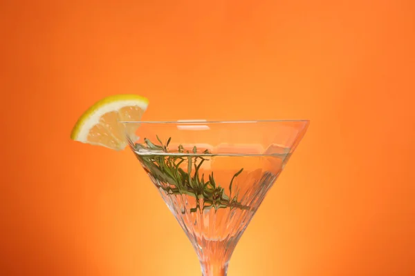 Martini Glas Uppfriskande Cocktail Med Citronskiva Och Rosmarin Orange Bakgrund — Stockfoto