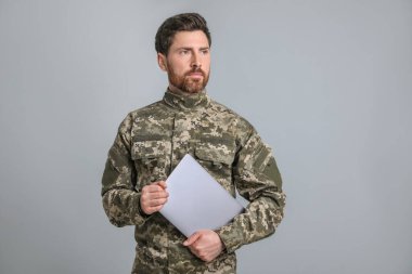 Soldier with laptop on light grey background. Military service clipart