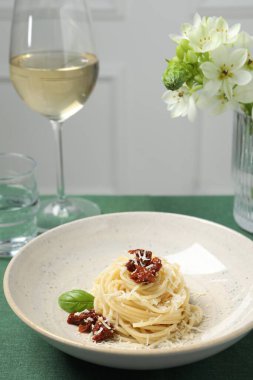 Masada servis edilen güneşte kurutulmuş domatesli ve parmesan peynirli leziz spagetti. Makarna yemeğinin enfes sunumu