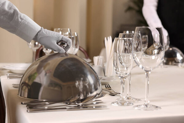Woman setting table in restaurant, closeup. Professional butler courses