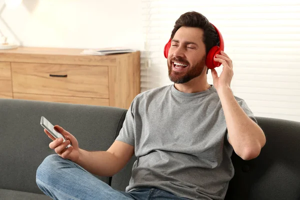 Hombre Feliz Escuchando Música Con Auriculares Sofá Interior —  Fotos de Stock