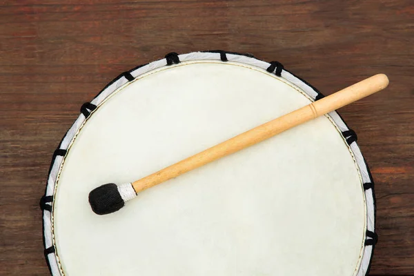 stock image Modern drum with drumstick on wooden table, top view. Percussion musical instrument