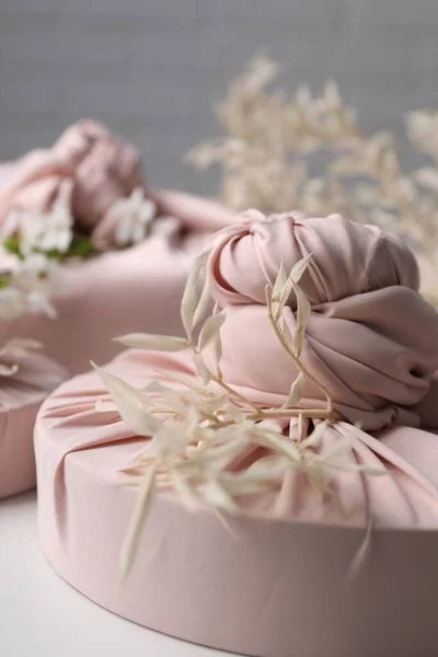 Técnica Furoshiki Presentes Embalados Tecido Rosa Ramos Secos Mesa Branca — Fotografia de Stock