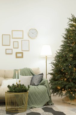 Oturma odasında altın ışıkları olan güzel Noel ağacı