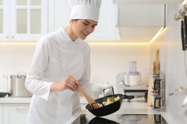 Mutfakta lezzetli yemekler pişiren profesyonel bir aşçı.