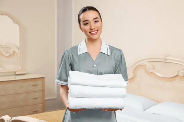 Genç Oda Hizmetçisi Otel Odasında Bir Yığın Temiz Havlu Tutuyor — Stok fotoğraf