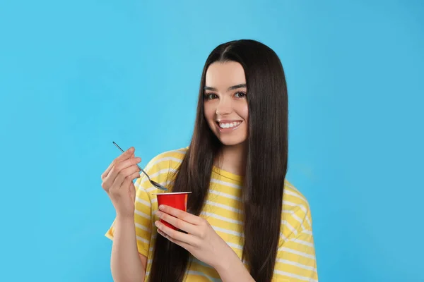 Chica Adolescente Feliz Con Delicioso Yogur Cuchara Sobre Fondo Azul — Foto de Stock