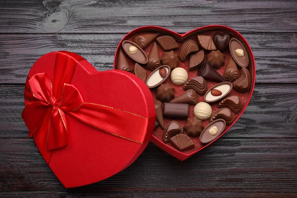 Hjärtformad Låda Med Läckra Chokladgodis Träbord Ovanifrån — Stockfoto