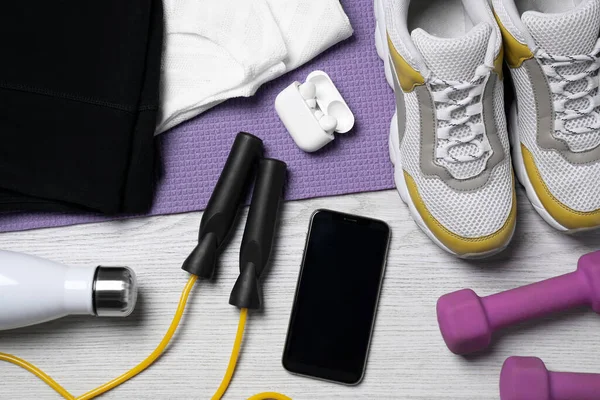 Smartphone Wireless Earphones Clothes Sports Equipment White Wooden Table Flat — Stock Photo, Image