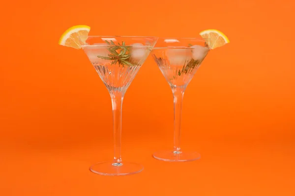 Martini Glazen Verfrissende Cocktail Met Citroenschijfjes Rozemarijn Oranje Achtergrond — Stockfoto
