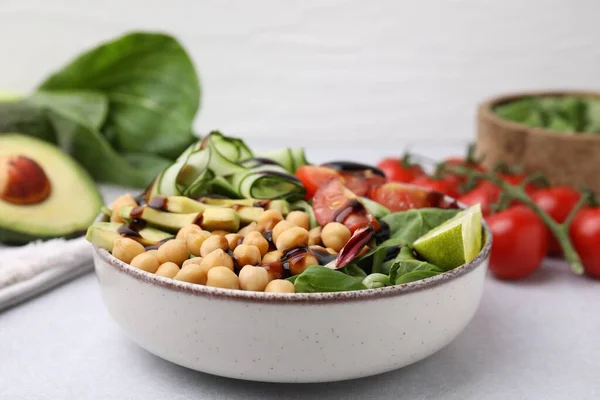 stock image Delicious salad with chickpeas, vegetables and balsamic vinegar on white table, closeup