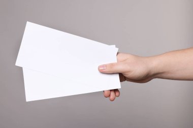 Gri arka planda el ilanları tutan kadın, yakın plan. Tasarım için model