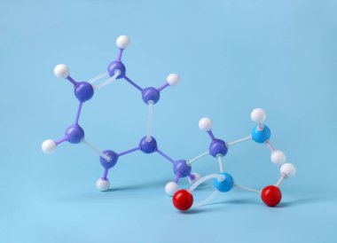 Açık mavi arka planda fenilalanin molekülü. Kimyasal model