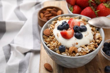 Tasty granola, yogurt and fresh berries in bowl on wooden board, closeup with space for text. Healthy breakfast clipart