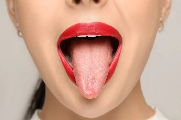 Frau Zeigt Ihre Zunge Auf Hellem Hintergrund Nahaufnahme — Stockfoto