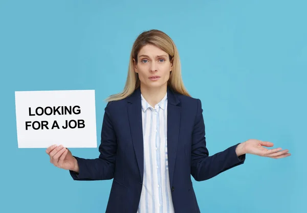 雇用されていない女性がフレーズでサインを保持ライトブルーの背景に仕事を探しています — ストック写真