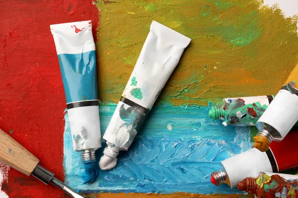 Tubos Tintas Óleo Coloridas Espátula Sobre Tela Com Pintura Abstrata — Fotografia de Stock