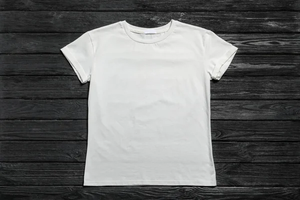 黑色木制背景的时尚白色T恤 顶视图 — 图库照片