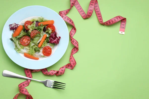 新鮮な野菜サラダのプレート 薄緑の背景にフォークと測定テープ テキストのためのスペースとフラットレイアウト 健康的な食事のコンセプト — ストック写真