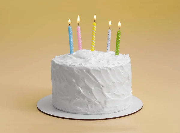 Delicious cake with cream and burning candles on yellow background