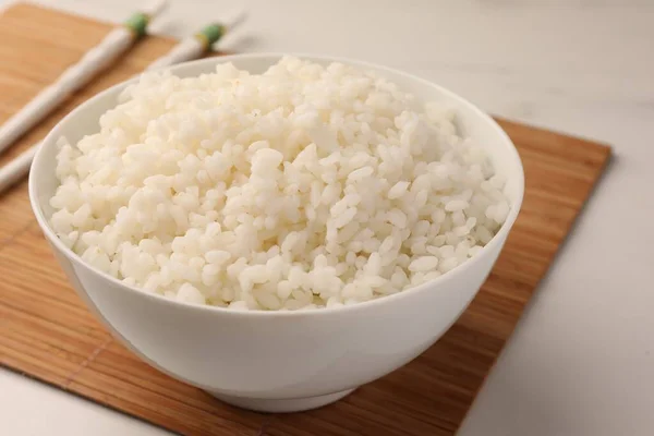 Schüssel Mit Köstlichem Reis Und Stäbchen Auf Weißem Tisch Nahaufnahme — Stockfoto